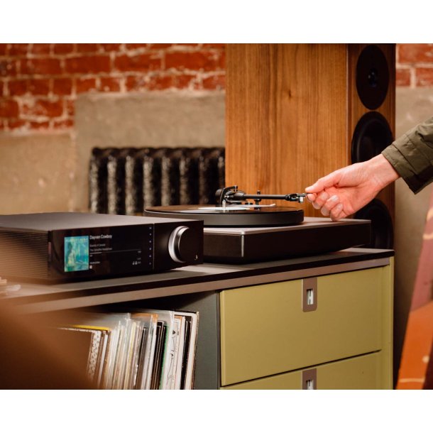 Foto af en mand der betjener en pladespiller med Cambridge Audio EVO 300 forst�rkeren ved siden af