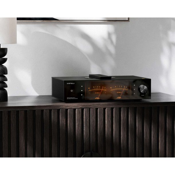 Et foto af Eversolo DMP-A8 Gen 2 Master Edition p� et m�rkt m�bel med et maleri og en lampe