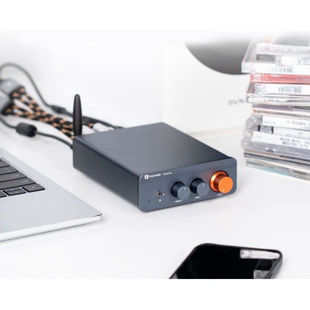 Et foto af Fosi Audio BT20A Pro p� et skrivbord ved en computer